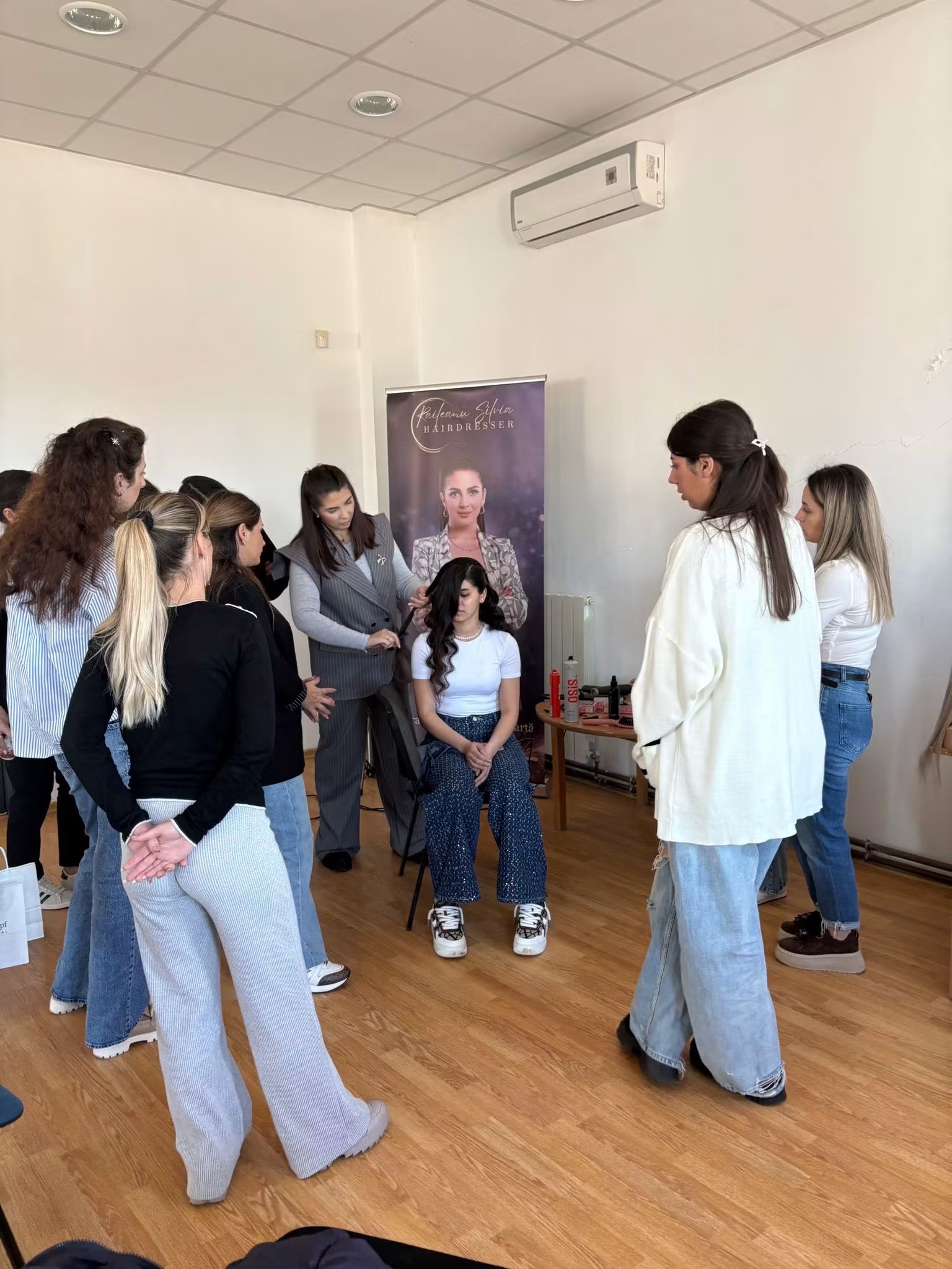 Silvia demonstrând o tehnică de coafat unei cursante